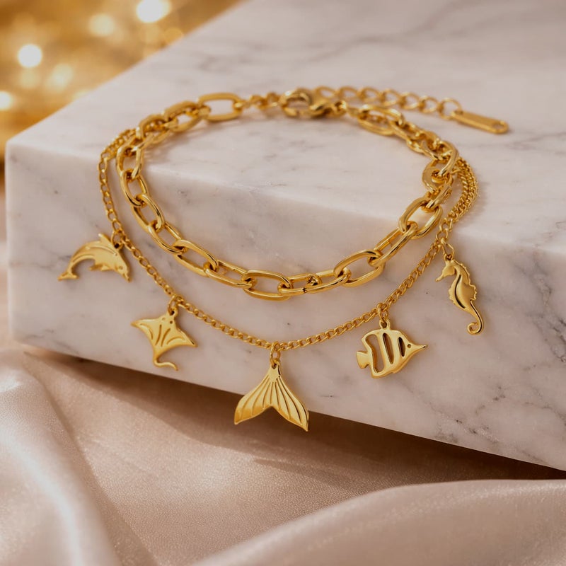 انسيال ذهبي مصنوع من الستانلس ستيل المقاوم للصدأ، بتصميم يجمع بين السلاسل الرفيعة والعريضة مع دلايات أشكال بحرية ساحرة، وقفل قابل للتعديل ليناسبكِ. - Image 3